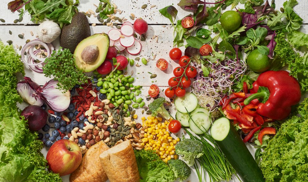 Cut up fruits and veggies on white background.