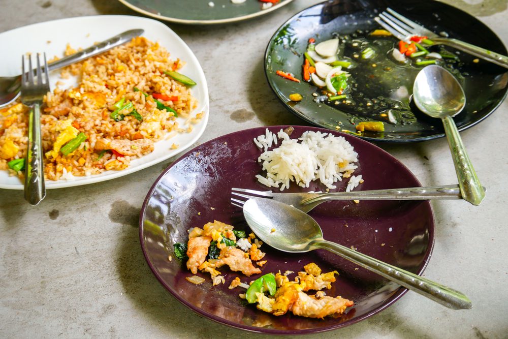 Plates with leftover food and cutlery.