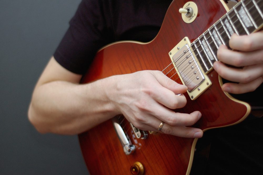 Playing a Gibson guitar.