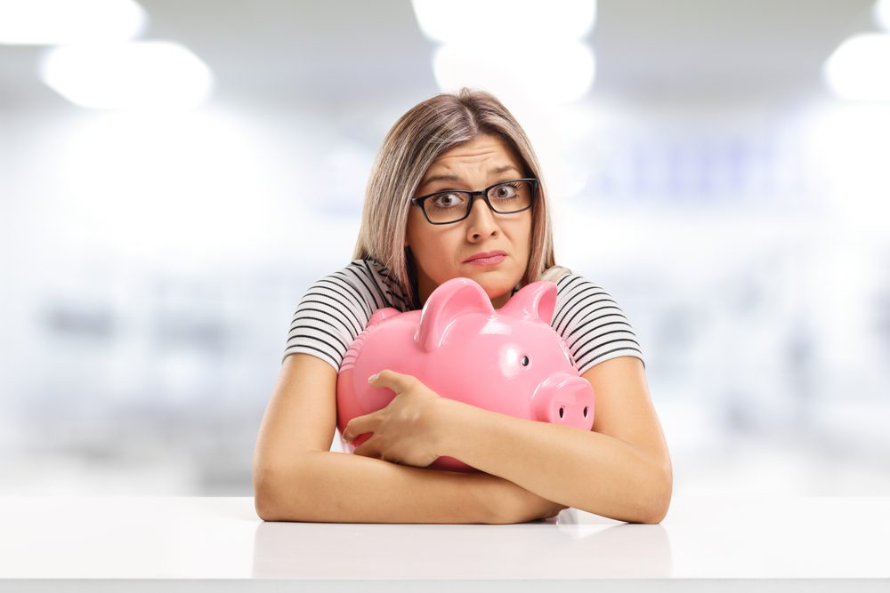 Hugging a piggypbank. 
