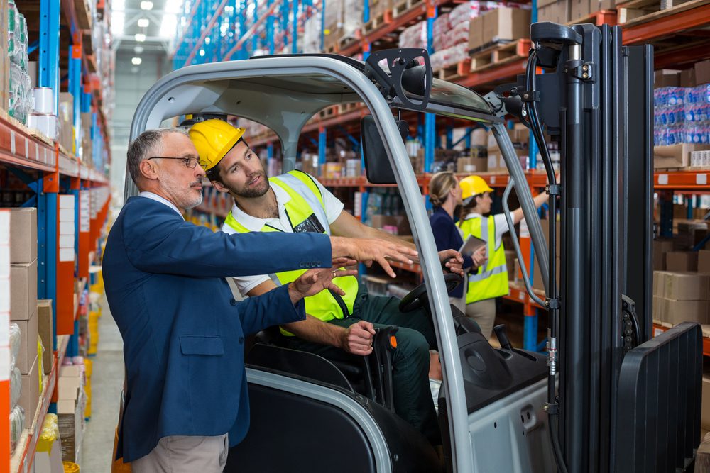 Boss and worker in warehouse.