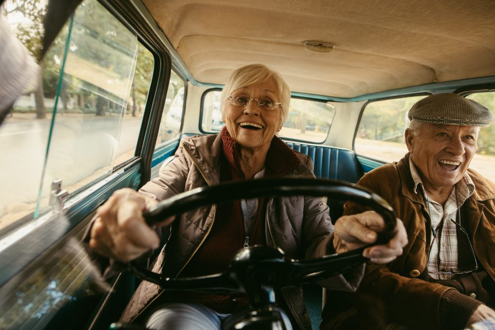 Seniors driving and smiling.