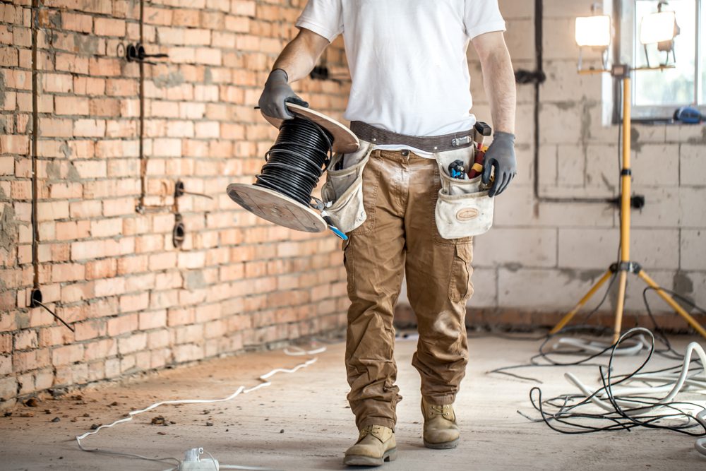 Electrician carrying cables.